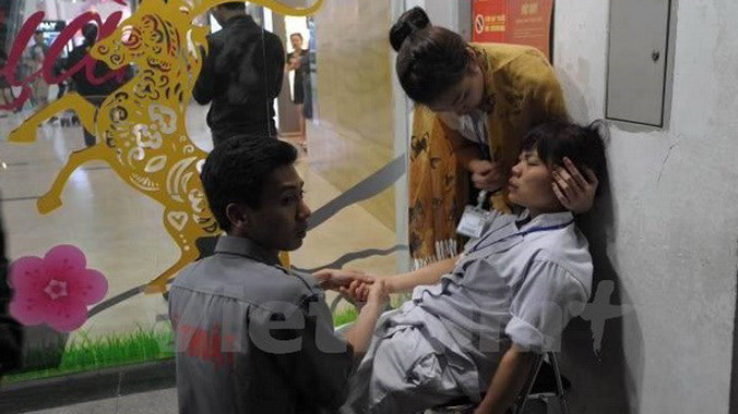 Nạn nhân bị ngộ độc đang được sơ cứu tại chỗ. Ảnh: Minh Sơn/Vietnam+.