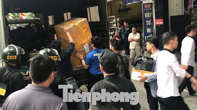 Cảnh sát khám xét và thu giữ nhiều tài liệu, vật chứng tại cửa hàng Nhật Cường ngày 9/5. Ảnh: TPO