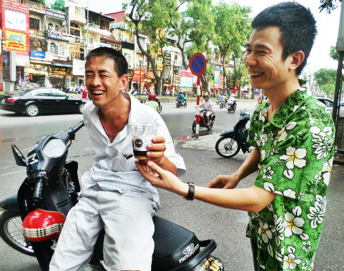 Những người lao động ở khu vực Giảng Võ thường không lạ gì người chủ quán thân thiện. Họ khá thoải mái khi được nhận những ly cà phê như vậy từ vài năm nay. Ảnh: Lê Thương