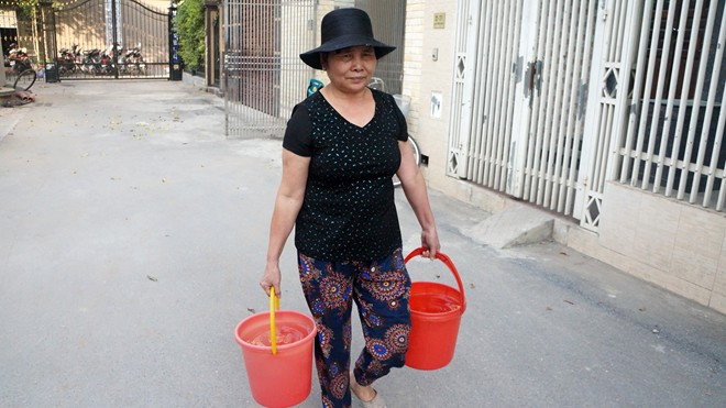 Bà Mơ đi xin nước về dùng tạm. Ảnh: Tuấn Minh