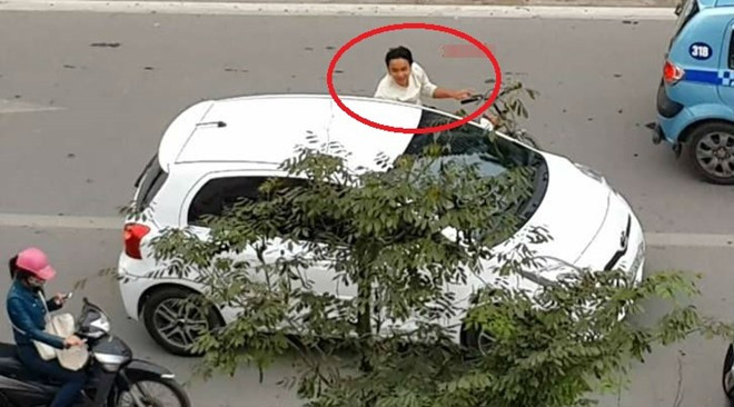 Người đàn ông đi xe đạp xin tiền xế hộp mua bánh mỳ trên đường Nguyễn Trãi. Ảnh: otofun