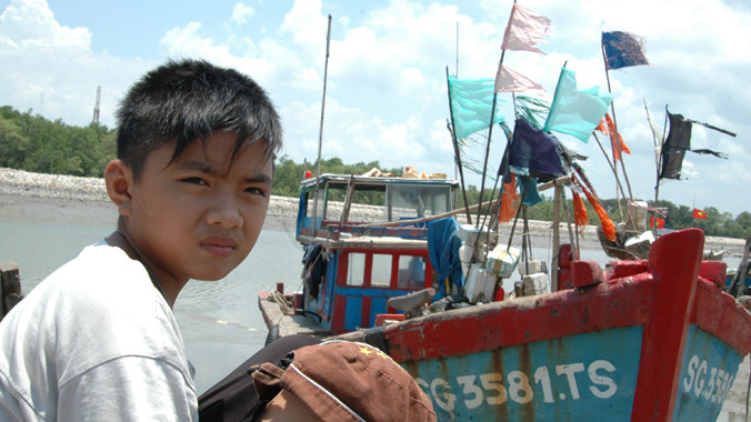 Cảng cá đìu hiu. Bé Đỗ 13 tuổi không biết chữ đang đợi bố đánh cá trở về. Ảnh: T.N.A 