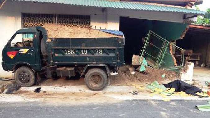 Sau khi gây tai nạn chết người, chiếc xe tải húc thủng tường nhà dân. Ảnh: V. Linh.