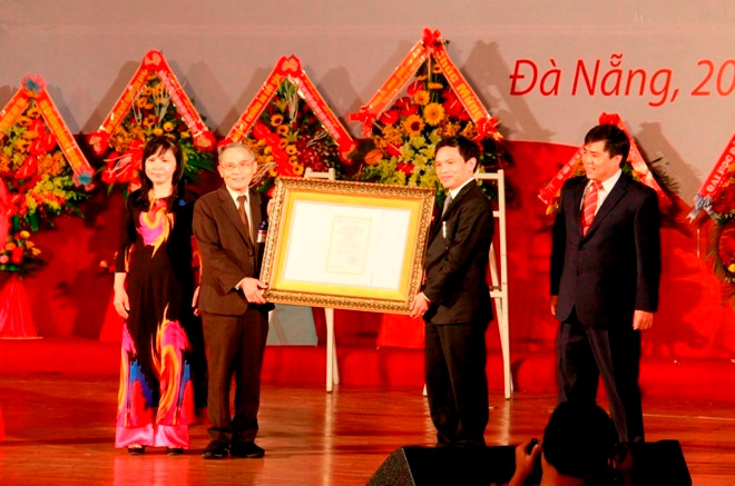 Nhà giáo ưu tú Lê Công Cơ, Hiệu trưởng trường ĐH Duy Tân (bìa trái) vinh dự đón nhận Giấy chứng nhận KĐCLGD cho nhà trường. Ảnh: Thanh Trần.