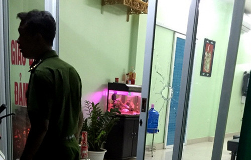 Cửa kính ở cửa hàng cầm đồ bị một vết thủng, nghi súng bắn xuyên qua. Ảnh: Sơn Dương.