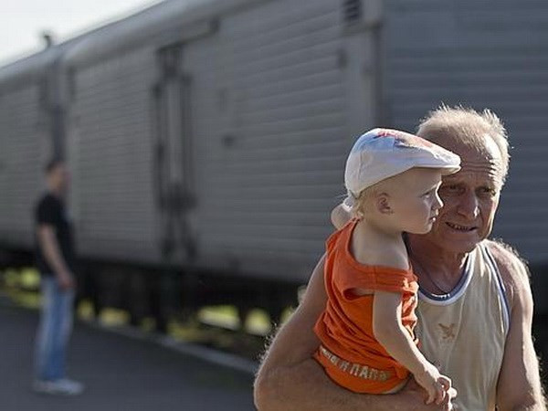 Người dân địa phương bên cạnh đoàn tàu chứa thi thể các nạn nhân vụ máy bay MH17 rơi. (Nguồn: News Corp)
