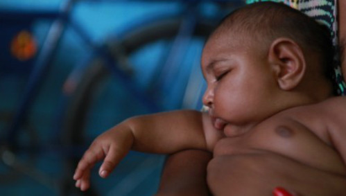 Bé Luiz Felipe nằm ngủ trên tay mẹ. Ảnh: CNN.