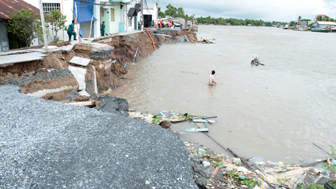 Hàng trăm mét đường đang thi công bị trôi xuống sông. Ảnh: VietNamNet.