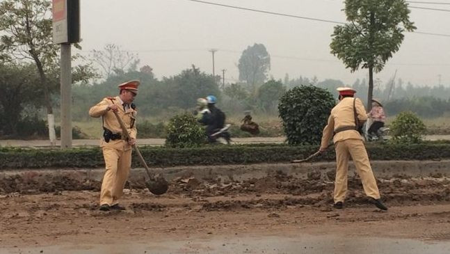 Các chiến sĩ CSGT đang dọn dẹp bùn đất.