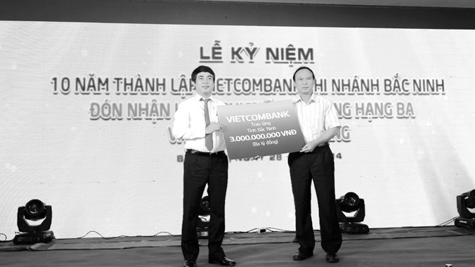 Ông Nghiêm Xuân Thành - Tổng giám đốc Vietcombank (bên trái) trao số tiền ủng hộ 3 tỷ đồng xây dựng trường học trên địa bàn tỉnh Bắc Ninh 