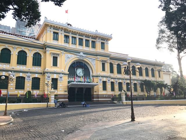 Khoảng sân Bưu điện thành phố vắng khách, chỉ có bóng dáng bảo vệ túc trực.