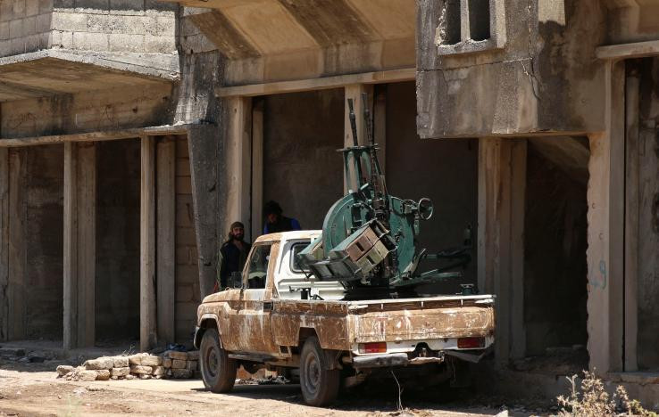 2 tay súng của Quân đội Syria Tự do nghỉ ngơi bên khẩu súng máy chống máy bay ở Quneitra, Syria. Ảnh: Reuters