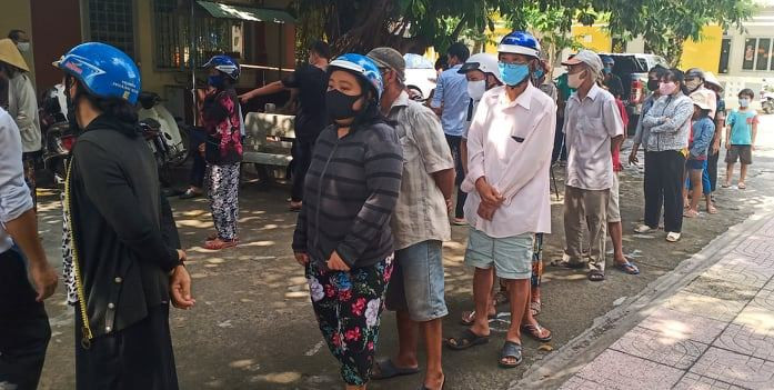 Hàng người sát nhau chờ nhận gạo.