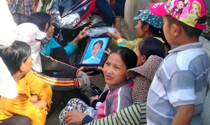 Người thân mang theo di ảnh chị Th. đến nơi cơ quan công an tổ chức khai quật tìm xác. Ảnh: Đ.T