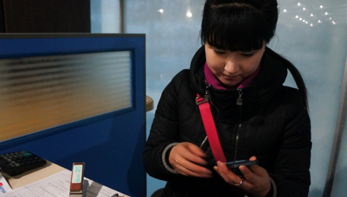 Nhân viên của nhà mạng Koryolink (Triều Tiên) đang lắp SIM cho khách du lịch.