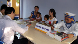 Người dân cùng lính đọc sách, báo tại điểm Bưu điện văn hóa đảo Trường Sa 