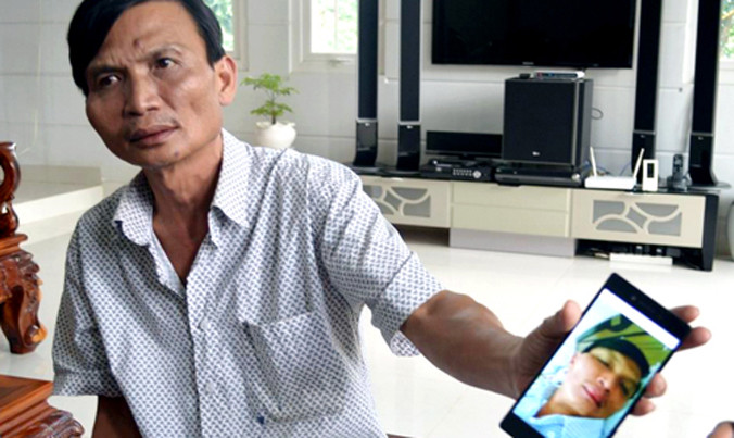 Ông Hưng đưa hình ảnh của mình lúc bị đánh. Ảnh: Kh.Uyên/VnExpress