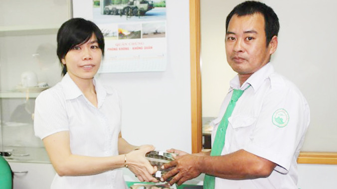 Tài xế Vương Hiếu Thảo trao tiền cho khách.