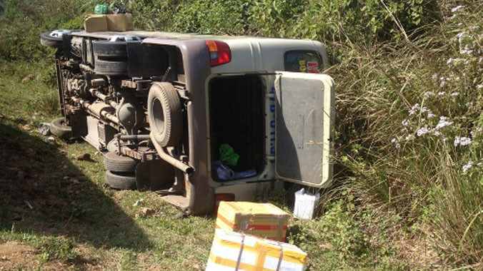 Chiếc xe khách lật nghiêng dưới lề đường.