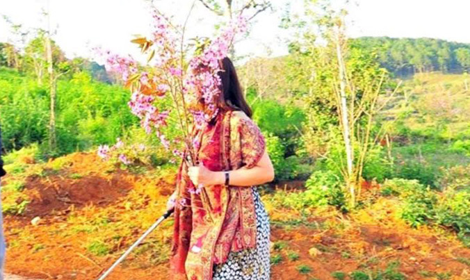 Bức ảnh bà Hiếu ôm bó hoa mai anh đào lan truyền trên mạng.