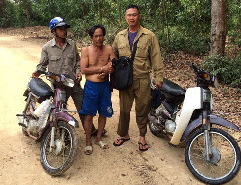 Đặng Văn Lợi giữa 2 cảnh sát hóa trang thành cán bộ lâm trường.