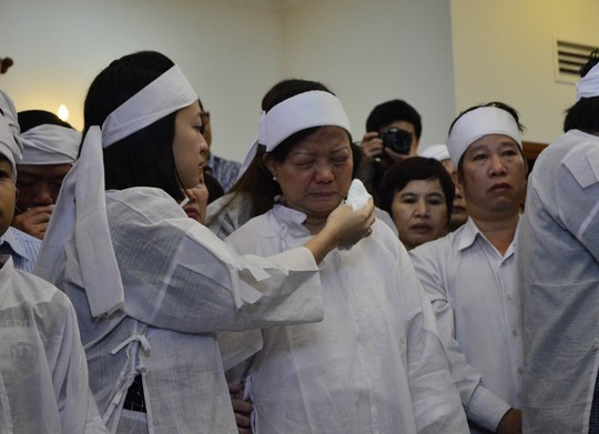Con gái ông Nguyễn Bá Thanh lau nước mắt cho mẹ trong giờ truy điệu sáng 16/2.