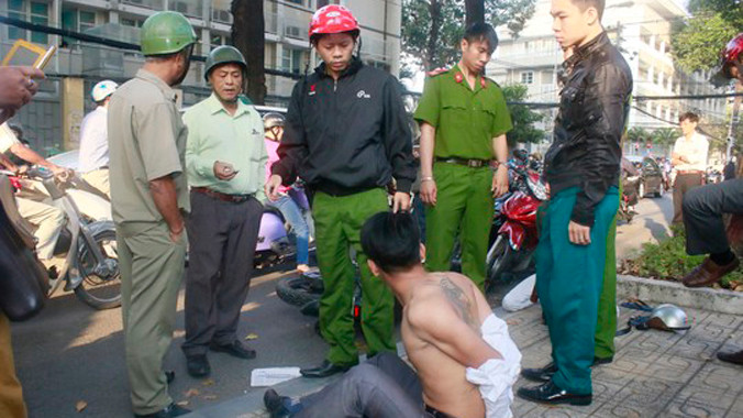 Một trong hai tên cướp bị người dân bắt tại hiện trường.