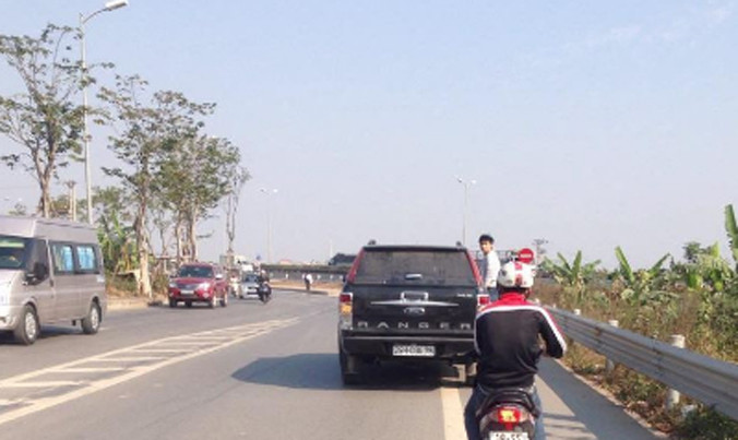 Nam thanh niên đu bám bên hông chiếc xe hạng sang. Ảnh cắt từ clip.