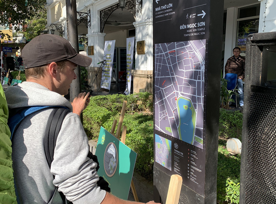 Du khách xem và góp ý kiến về bộ nhận diện thương hiệu làng nghề của Hà Nội.