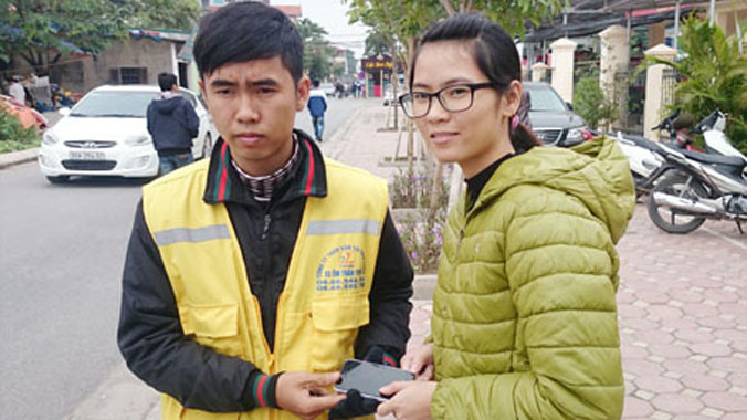 Chị Long nhận lại chiếc điện thoại từ anh Vũ Tuấn Hoàn.