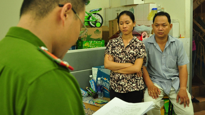 Vợ chồng Thanh nghe đọc lệnh bắt. Ảnh: C.A