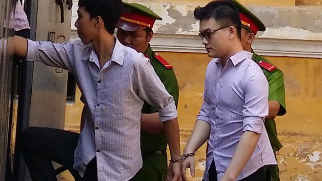 Hung thủ (đeo kính) bị dẫn giải sau phiên tòa