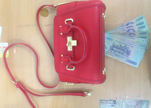 Chiếc túi xách và tiền mặt được cảnh sát trả cho bị hại. Ảnh: Quốc Thắng.