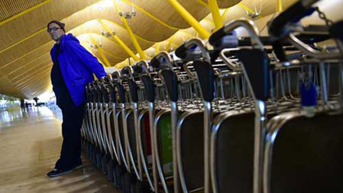 Ông Valentin Giorgiev đứng dựa vào những chiếc xe đẩy ở nhà ga số 4 của sân bay Madrid Barajas Adolfo Suarez. Ảnh: AFP.