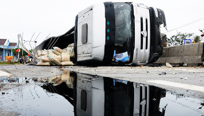 Xe tải tông vỡ dải phân cách, lật ngang chắn nửa lòng đường. Ảnh: Minh Hoàng.