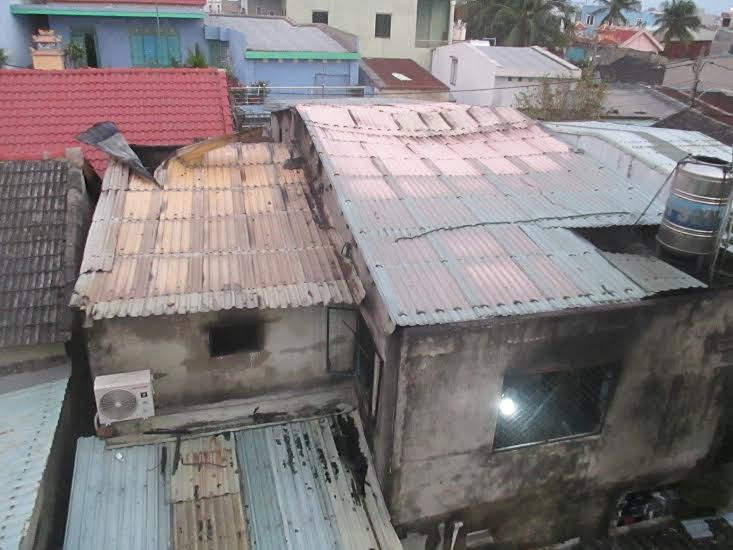 Cảnh sát PC&CC phải gỡ bớt phần mái tôn căn nhà để khói thoát ra.