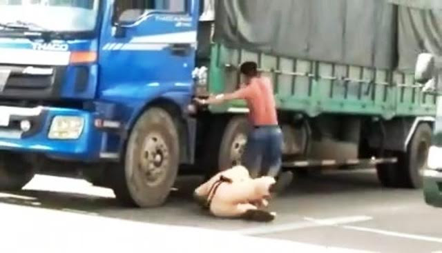 Hình ảnh hai người giằng co dưới đường. Ảnh cắt từ clip. 