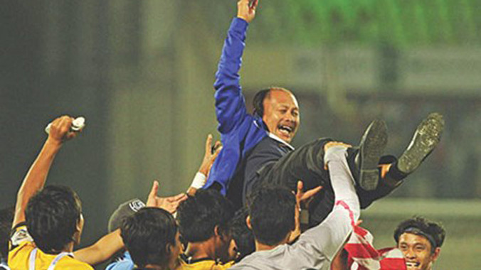 HLV Ismail Razip được các cầu thủ tung hô sau khi cùng U-23 Malaysia vô địch Gold Cup 2015. Ảnh: The Star.