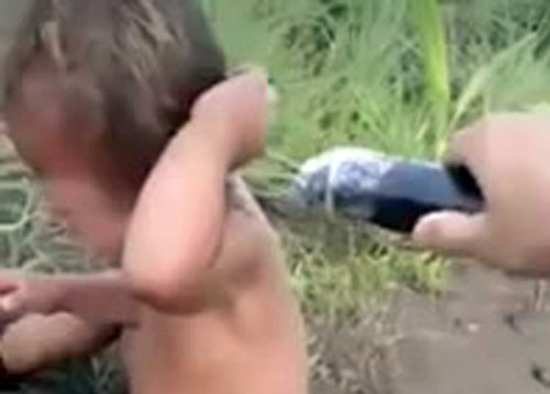 Cảnh quay bé trai bị Dũng dùng roi điện chích. Ảnh cắt từ clip