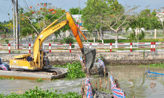 Máy kube đang đắp đập ngăn mặn ở huyện Vị Thủy. Ảnh: Hòa Hội.