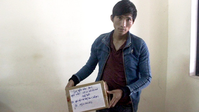 Đối tượng Lê Đức Đệ - cùng "hộp quà" trong ngày dựng lại hiện trường khi bị bắt