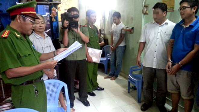 Phương (áo xanh) nghe đọc lệnh bắt. Ảnh: Q.T