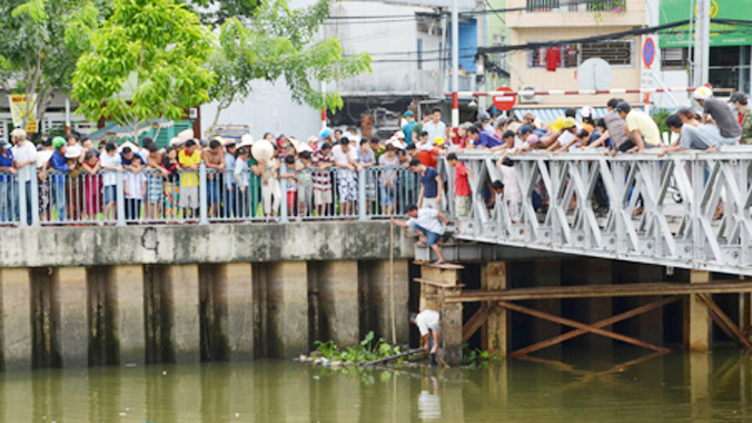 Thi thể nam học sinh được người dân kéo vào chân cầu tạm