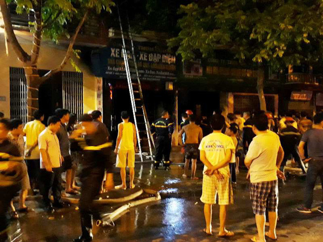 Người dân và lực lượng chức năng nhanh chóng đưa 3 mẹ con trên tầng 2 ngôi nhà bị cháy ra ngoài.