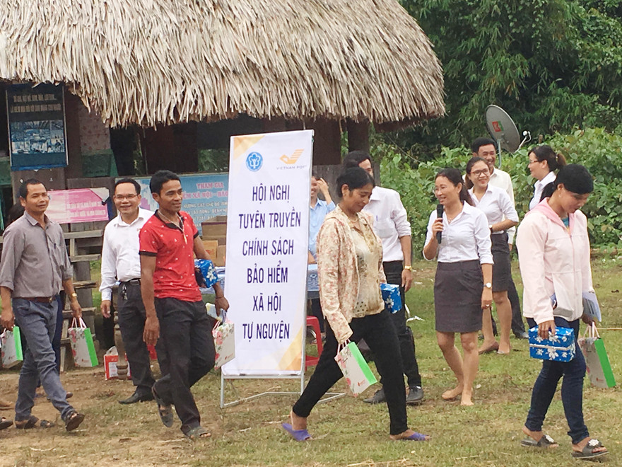 Tuyên truyền viên Trần Thị Mai Phương chân đất, mải mê tư vấn cho bà con đồng bào Cơ Tu. Ảnh: An Phú