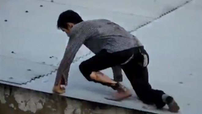 Sau khi gây án, quần áo bị cháy xém, Nam leo lên nóc nhà định bỏ trốn nhưng bất thành. Ảnh: YouTube