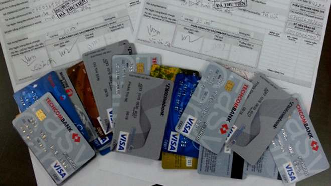 Giấy biên nhận nạn nhân nộp tiền và những chiếc thẻ được chúng rút tiền của các bị hại