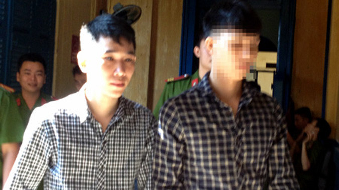 Bị cáo Hùng (bên trái) được dẫn giải sau phiên tòa.