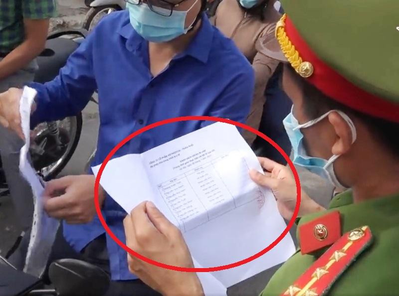 Công an Thanh Trì kiểm tra giấy đi đường có kèm lịch trực (vòng tròn đỏ) của người dân ngày 30/8, sau khi thành phố đã yêu cầu bỏ.