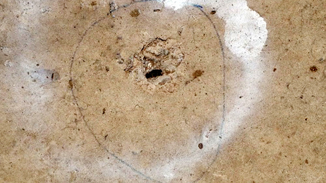 Một trong nhiều vết đạn dưới sân nhà nghỉ. Ảnh: Ái Nam